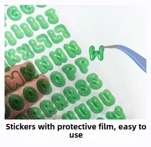 Détail macro de stickers lettres 3D vertes retirés avec une pince pour journaux créatifs