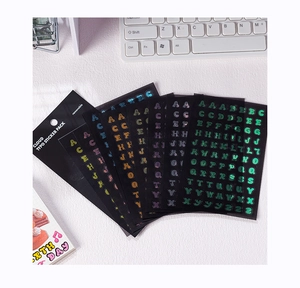 Vue à plat d'autocollants alphabets laser colorés avec finition holographique sur table