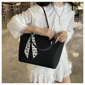 Detail of black woven tote bag with houndstooth silk scarf on model for daily use