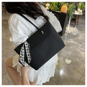 Detail of black woven texture tote bag featuring a chic houndstooth scarf ornament