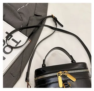 Detail of vintage box bag featuring gold double zippers and adjustable leather strap