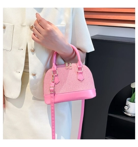 Detailed side view of pink two-texture dome bag with gold hardware and shoulder strap