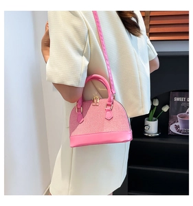 Pink shell handbag detail with fine cross-hatch texture and gold-tone zippers for women