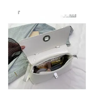 Vue intérieure montrant la grande capacité de rangement du sac bandoulière en cuir blanc