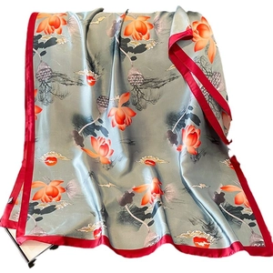 Elegant grey silk scarf with lotus print and red border, gracefully draped for summer