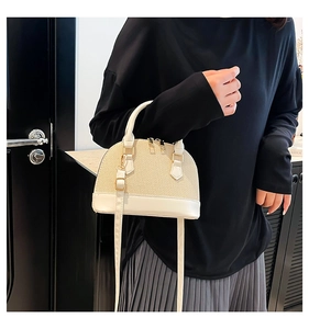 Detail of cream woven shell bag with synthetic leather base and adjustable strap