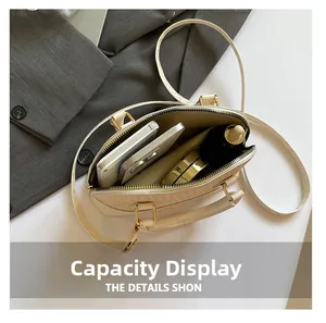Spacious interior of beige crossbody shell bag showing storage for phone and cosmetics