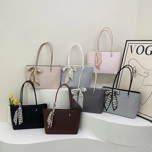Chic woven tote bags in six colors with decorative silk scarves on tiered display