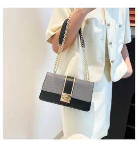 Detail of grey fabric and black leather contrast handbag with gold twist lock buckle
