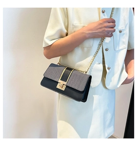 Detailed view of the chain strap and gold twist lock on this woven patchwork square bag