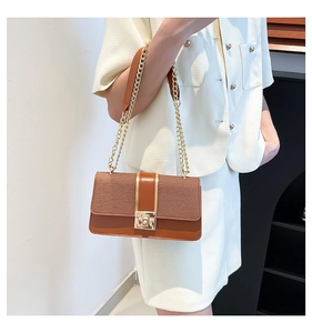 Detail of vintage patchwork crossbody bag featuring brown leather and gold chain strap