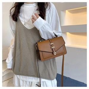 Brown leather crossbody bag detail featuring elegant gold hardware and classic flap closure