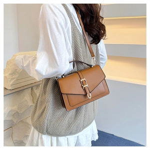 Brown retro crossbody bag shown on model with vintage gold buckle and matte finish