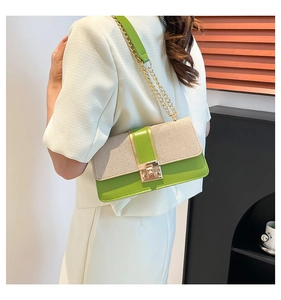 Detail of avocado green and cream textured crossbody bag with gold chain strap on model