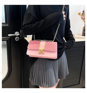 Detailed close-up of pink patchwork woven leather handbag with gold chain and twist lock