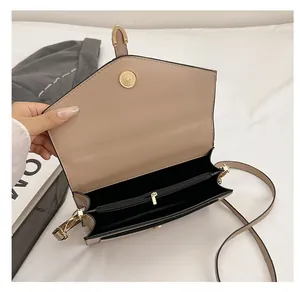 Detail view of the beige crossbody bag's dual inner compartments and zipper pocket