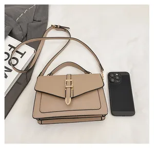 Size comparison of khaki leather crossbody bag with a smartphone and a magazine
