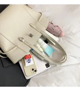 Detail showing high-capacity beige tote bag with litchi texture and silver buckle