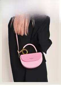 Detailansicht der rosa Leder Satteltasche mit vertikaler Textur und goldenem Metallgriff