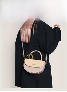 Details einer Kontrast-Satteltasche mit goldenem Knotengriff und Akkordeon-Falten