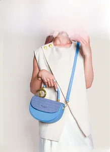 Detail der blauen Satteltasche mit goldenem Metallgriff und strukturierter Klappe