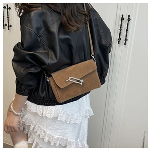 Brown suede crossbody square bag with silver chain buckle shown on model's shoulder