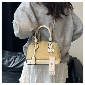 Dettaglio posteriore di una borsa a conchiglia vintage con motivo floreale cachi su ecopelle