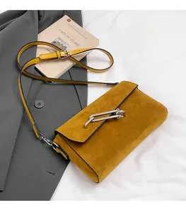 Detail of ginger suede square crossbody bag with silver metal chain buckle and strap
