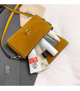 Detail of suede crossbody bag interior showcasing ample space for phone and perfume