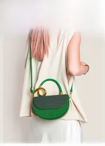Detailaufnahme der smaragdgrünen Satteltasche mit goldener Spiralschnalle und Ledertextur