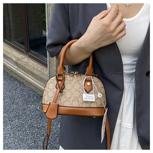 Dettaglio borsa Boston vintage monogramma con manici in pelle marrone e zip dorata