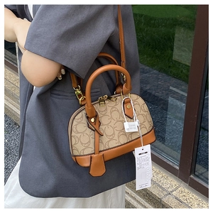 Dettaglio della borsa beige vintage con finiture in pelle marrone e fibbie dorate