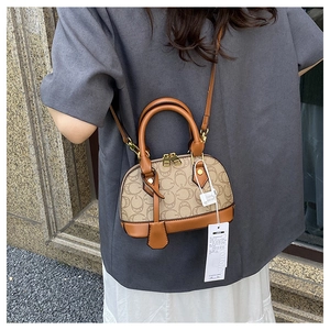 Dettaglio di una mini borsa a cupola vintage con monogramma KMKA e tracolla in pelle
