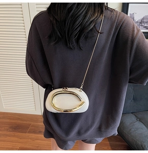 Detailed back view of a white leather evening bag with golden buckle and chain strap