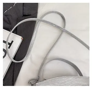 Detailed close-up of flexible thin shoulder strap and shiny silver sequin texture