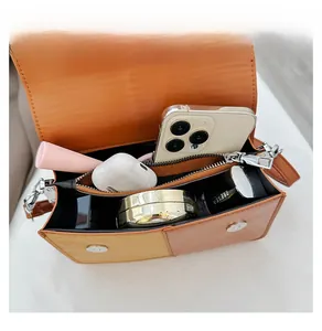 Interior view of orange crossbody bag showing large capacity for phone and makeup items