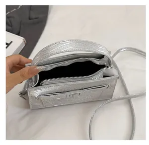 Detail showing the spacious interior and silver metallic finish of this women's handbag