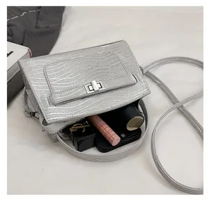 Detail view of silver textured crossbody bag showing interior capacity and metal lock