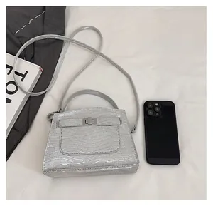Detail view of silver wavy textured handbag showing size comparison with a smartphone