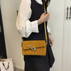 Chic mustard yellow suede crossbody bag with stylish silver buckle and envelope flap design