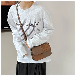 Detailed view of brown patchwork crossbody bag with textured leather and adjustable strap