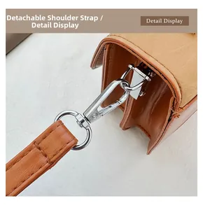 Detail display of brown leather detachable shoulder strap with silver metal spring hook
