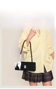 Detail of black underarm bag with silver rhinestone buckle and white silk scarf handle