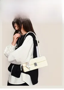 Detail of cream baguette bag with rhinestone metal buckle and floral silk scarf strap