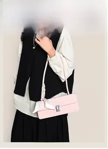 Close-up of pink leather baguette bag with silver rhinestone buckle and decorative silk scarf