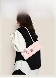 Pink baguette bag with lizard texture, silver metal clasp, and silk scarf detail