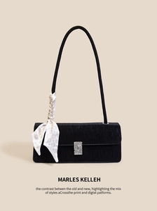 Detail of black baguette bag featuring a silver rhinestone buckle and patterned silk scarf
