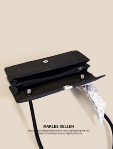 Detail view of black textured baguette bag showing dual inner compartments and decorative scarf