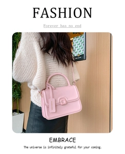 Detail of pink PU leather crossbody bag with decorative buckle and logo tag