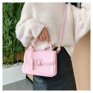Detail of light pink PU leather crossbody bag with adjustable strap and fashion tag